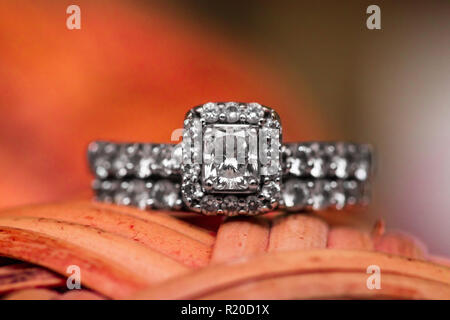 Makroaufnahme eines Diamanten Hochzeit Ring auf ein rotes Objekt mit einem schönen Bokeh Hintergrund. Stockfoto