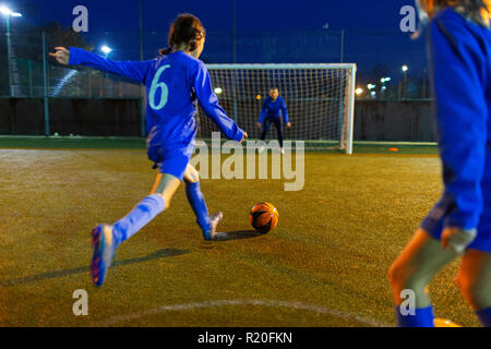 Mädchen Fußball-Spieler kicken BALL RICHTUNG TOR Stockfoto