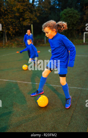 Mädchen Fußball-Spieler üben auf dem Feld Stockfoto