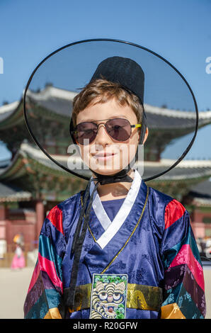 Eine Junge lächelt und posiert für ein Portrait, die traditionelle koreanische Kleid vor ein Tor in Gyeongbokgung Palast in Seoul, Südkorea. Stockfoto