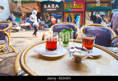 Kairo, Ägypten - Dezember 21, 2017: ein Glas heißer schwarzer Tee genießen, mit frischer Minze im Außenbereich Teehaus, in belebten Al Khayama Straße, Trade Boxes Stockfoto