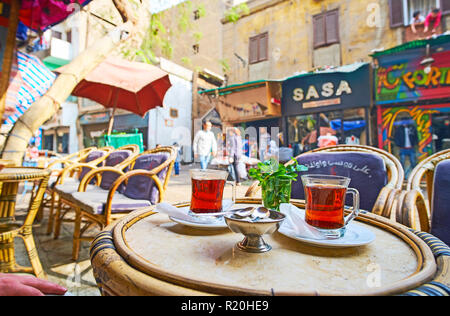 Kairo, Ägypten - Dezember 21, 2017: Zwei Gläser heißen schwarzen Tee mit frischer Minze im Outdoor Cafe Al Khayama Straße mit Blick auf die Stores, Anbieter, sh Stockfoto