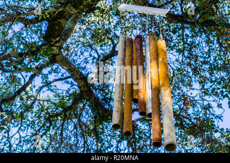 Alt und rostig, Metall Windspiel, hängen von der Filiale einer live oak tree Stockfoto