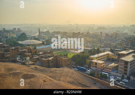 Beobachten Sie den Sonnenuntergang über den nebligen Wohnviertel von Kairo aus die Mauer der Zitadelle von Saladin, Ägypten. Stockfoto