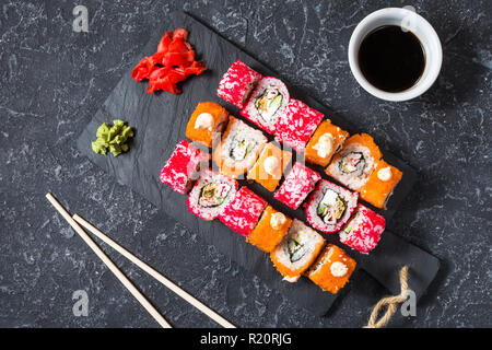 Verschiedene sushi Rollen auf Platte auf Stein serviert. Ansicht von oben Stockfoto