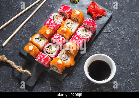 Verschiedene sushi Rollen auf Platte auf Stein serviert. Stockfoto