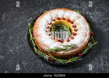 Christmas Cake mit getrockneten Beeren auf dunklen Tisch aus Stein. Stockfoto