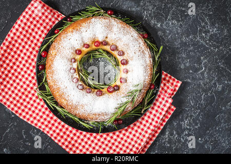 Christmas Cake mit getrockneten Beeren auf dunklen Tisch aus Stein. Ansicht von oben Stockfoto