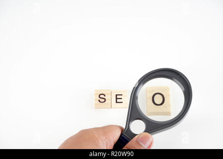 SEO, Search Engine Optimization Wort des Holz- Elemente, die mit den Buchstaben gesammelt und auch Lupe. Stockfoto