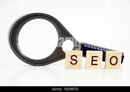 SEO, Search Engine Optimization Wort des Holz- Elemente, die mit den Buchstaben gesammelt und auch Lupe. Stockfoto