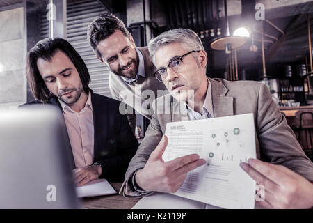 Reifer mann Arbeiten mit schweren Dokumente konzentriert Stockfoto