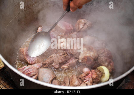 Das Mischen von gekochtem Lamm in Kessel. Vorbereitung der Chorba Suppe auf offenem Feuer, traditionelle Mahlzeit für viele nationale Spezialitäten, die in Europa, Afrika und Asien Stockfoto