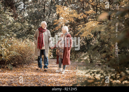 Angenehme senior Paar zu Fuß in den Wald Stockfoto