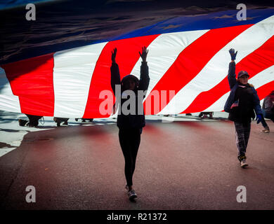 Eine riesige amerikanische Flagge auf der Fifth Avenue in New York während des Veterans Day Parade am Sonntag, 11. November 2018 durchgeführt. Weiß ursprünglich Armistice Day, der in diesem Jahr der Feiertag im Gedenken an den 100. Jahrestag des Endes des Zweiten Weltkrieges in der elften Stunde des elften Tag des elften Monats die Waffen schweigen fiel im Jahr 1918 markiert das Ende des Ersten Weltkriegs die Ferienwohnung wurde erweitert, alle amerikanischen Soldaten aus allen Kriegen. (Â© Richard B. Levine) Stockfoto