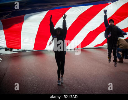 Eine riesige amerikanische Flagge auf der Fifth Avenue in New York während des Veterans Day Parade am Sonntag, 11. November 2018 durchgeführt. Weiß ursprünglich Armistice Day, der in diesem Jahr der Feiertag im Gedenken an den 100. Jahrestag des Endes des Zweiten Weltkrieges in der elften Stunde des elften Tag des elften Monats die Waffen schweigen fiel im Jahr 1918 markiert das Ende des Ersten Weltkriegs die Ferienwohnung wurde erweitert, alle amerikanischen Soldaten aus allen Kriegen. (© Richard B. Levine) Stockfoto