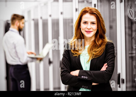 Techniker stehen mit verschränkten in einem Serverraum Stockfoto
