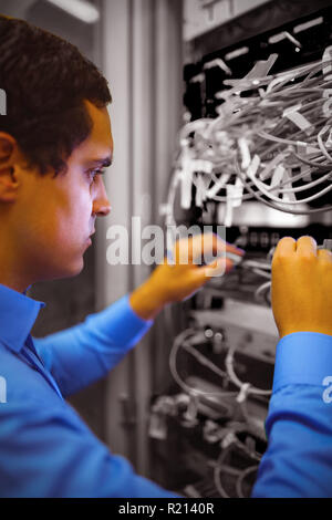 Techniker überprüfen Kabel in einem Rack montiert server Stockfoto