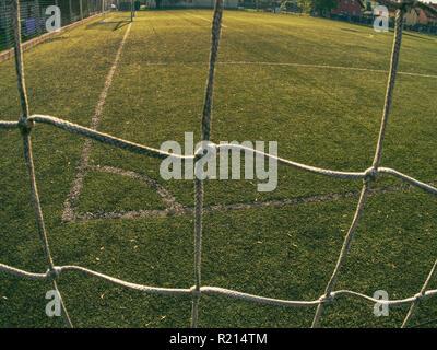 Fußball oder Football Ecke durch Net. Ansicht von hinter der Tribüne net mit unscharfen Stadion und Feld pitch Stockfoto
