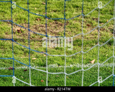 Fußball oder Football Ecke Linien durch Sicherheitsnetz. Ansicht von hinter der Tribüne net mit unscharfen Stadion und Feld pitch Stockfoto