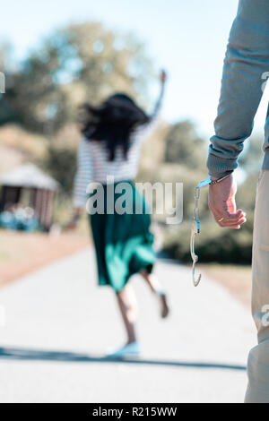 Nahaufnahme der männlichen Hand, daß Sein in Handschellen Stockfoto