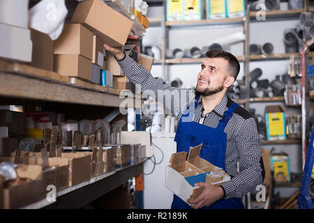 Erwachsene mann Arbeiter Sortierung Sanitärtechnik Details in der Werkstatt Stockfoto