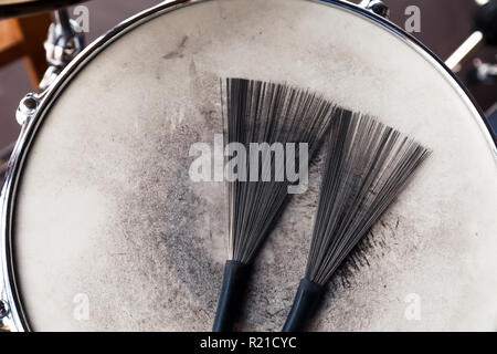 In der Nähe von ein paar schwarze Bürsten drum auf einem weißen schäbig drum. Konzept Konzert, Live Musik, Performance, musikalischen Abend in einem Restaurant Stockfoto