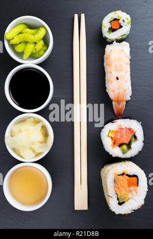 Typische asiatische Küche auf schwarze Küche Schiefer. Ingwer, Japanische Meerrettich Wasabi, Soja- und Fischsauce in kleinen weißen Schalen. Stäbchen. Sush Stockfoto