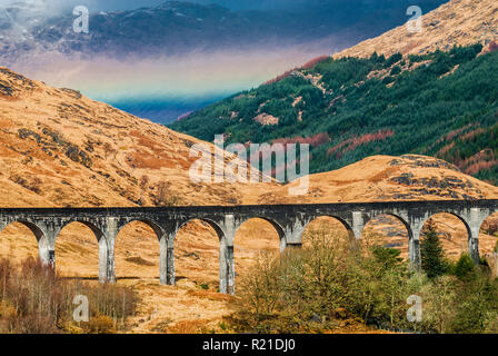 Ein Regenbogen über Glen Finnan und das glenfinnan Eisenbahnviadukt auf der berühmten Straße in die Inseln in Lochaber, Scottish Highlands Stockfoto