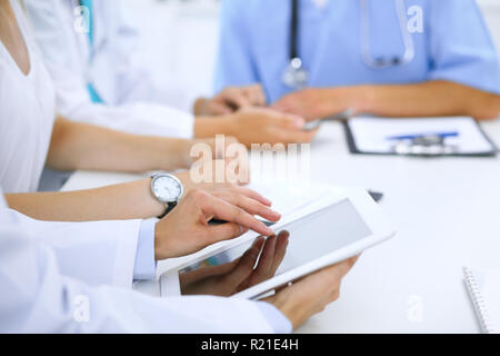 Arzt mit Tablet-PC auf medizinische Konferenz, Nahaufnahme. Gruppe von Kolleginnen und Kollegen in den Hintergrund Stockfoto