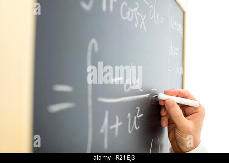 Nahaufnahme der Lehrer schreiben komplizierte mathematische Gleichung auf dem Schwarzen Brett. Stockfoto