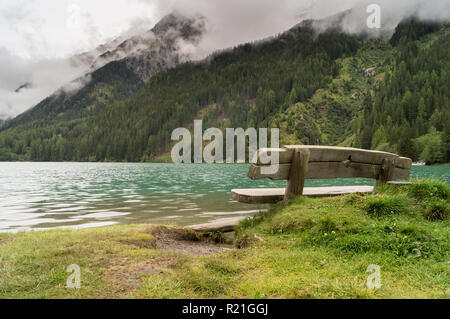 Panorama der Antholzer See sofort nach einem Sommer Sturm; Holzbank, im Vordergrund, am Ufer des Sees Stockfoto