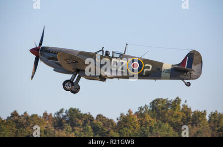 MONROE, NC (USA) - 10. November 2018: Eine britische Spitfire Kampfflugzeug steigt über die Bäume während der warbirds über Monroe Air Show. Stockfoto