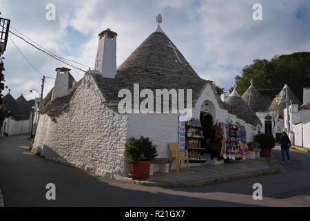 Alberobello, Italien, 11/15/2018: eine Frau an einem sonnigen Morgen im Alberobello Dorf, ist die Überschrift, die in der Nähe der Shop. Stockfoto