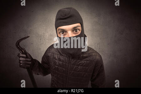 Einbrecher in schwarzer Kleidung und Sturmhaube auf seinem Kopf. Stockfoto