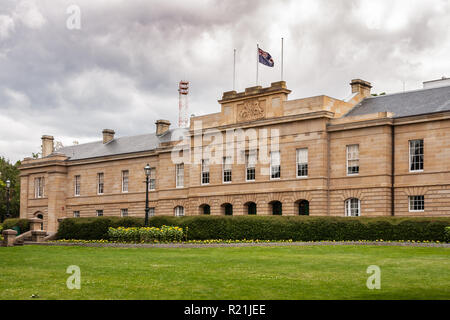 Hobart, Tasmanien, Australien - 13 Dezember, 2009: Braun-stein Parlament House Downtown unter schweren cloudscape und grünen Rasen. Flagge und Gelb Stockfoto