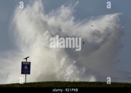 Portugiesische Küste während des Sturms seeig riesige Welle Splash. Das Warnschild sagt: Achtung, Gefahr, Meer gully Zone. Stockfoto