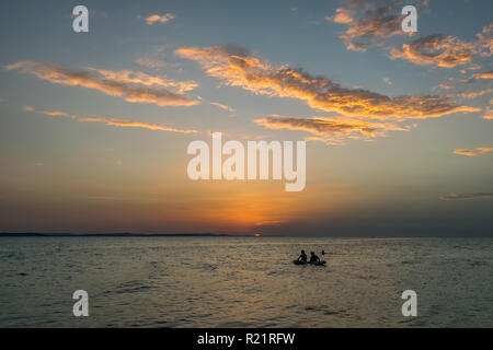 Menschen auf einem Floß sind, genießen Sie den Sonnenuntergang über dem Meer in Zadar, Kroatien. Die dalmatinische Küste hat eine feine Klima und ist bekannt für seine Sonnenuntergänge im Sommer. Stockfoto