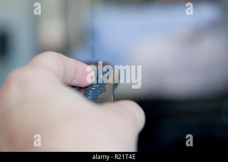 Hand zeigen Sie mit der Fernbedienung auf den Fernseher Stockfoto