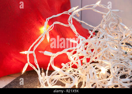 Ein weißes Bündel von Holiday Lights, neben einem roten santa Tasche Stockfoto