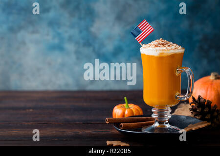 Pumpkin spice Latte mit Schlagsahne. Amerikanische Flagge auf der Oberseite. Holz- Hintergrund. Kopieren Sie Platz. Stockfoto