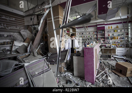 Gaza, Gaza, Palästina. 15 Nov, 2018. Ein Palästinenser, der in einer Apotheke durch einen israelischen Luftangriff Anfang dieser Woche im Gazastreifen beschädigt am 15. November 2018 Arbeiten. - Der Waffenstillstand, die heute sich erst nach der schlimmsten Eskalation zwischen Israel und dem Gazastreifen Aktivisten seit dem Krieg von 2014, aber die Situation ist immer noch die Vereinbarung eine scharfe Kontroverse innerhalb der israelischen Regierung provoziert. Credit: Mahmoud Issa/Quds Net News/ZUMA Draht/Alamy leben Nachrichten Stockfoto