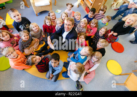 Neuwittenbek, Deutschland. 16 Nov, 2018. Daniel Günther (CDU), Ministerpräsident von Schleswig-Holstein, sitzt inmitten von Kindern in der "Lütt Wittenbeker' Day Care Center. Die allgemein Vorlesen Tag findet zum 15. Mal im Jahr 2018 und dieses Mal unter dem Motto "Natur und Umwelt" statt. Credit: Frank Molter/dpa/Alamy leben Nachrichten Stockfoto