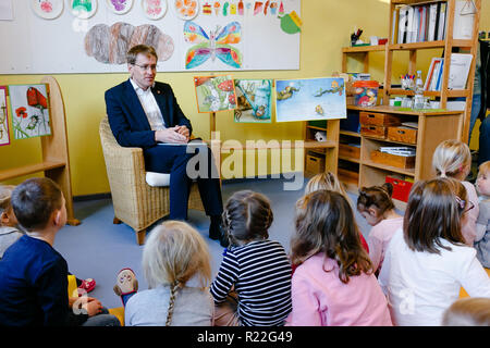 Neuwittenbek, Deutschland. 16 Nov, 2018. Daniel Günther (CDU), Ministerpräsident von Schleswig-Holstein, sitzt vor der Kinder in der "Lütt Wittenbeker' Day Care Center. Die allgemein Vorlesen Tag findet zum 15. Mal im Jahr 2018 und dieses Mal unter dem Motto "Natur und Umwelt" statt. Credit: Frank Molter/dpa/Alamy leben Nachrichten Stockfoto