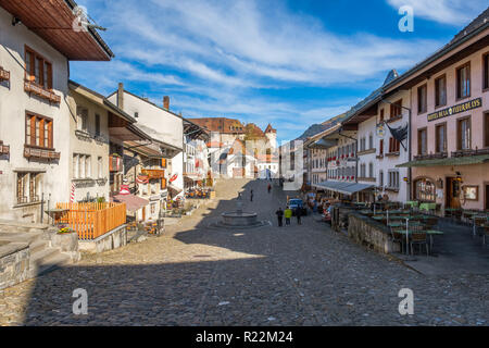 Mittelalterliche Straße mit reatuarants bis zu den Gruyeres Schloss, Schweiz, im Herbst Licht. Stockfoto