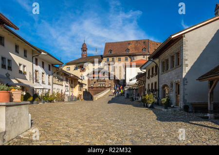 Touristen auf dem alten mittelalterlichen Straße in Bulle, Schweiz, im Herbst Licht. Stockfoto