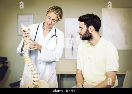 Physiotherapeut, Patienten zu erklären, die Wirbelsäule Modell Stockfoto