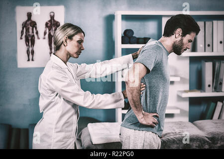 Physiotherapeut untersucht mans zurück Stockfoto