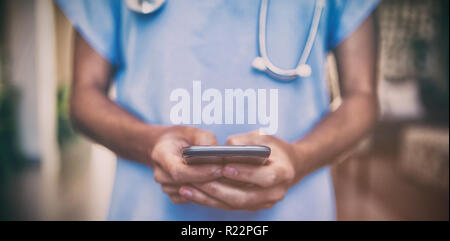 Arzt mit Mobiltelefon im Krankenhaus Stockfoto