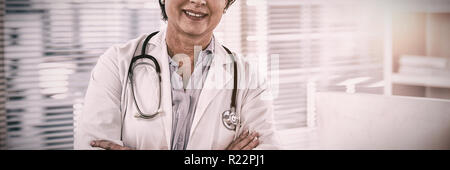 Porträt eines lächelnden Frau Doktor stand mit verschränkten Armen Stockfoto