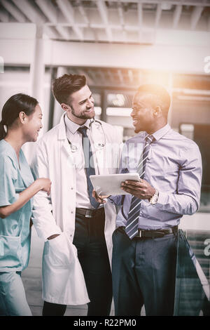 Krankenschwester und Arzt Diskussion mit Geschäftsmann Stockfoto